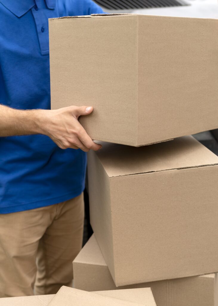 Caisse carton expédition avec livreur en arrière-plan