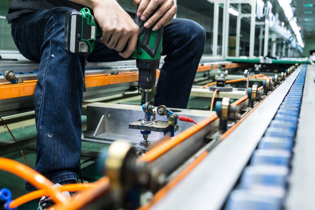 Technicien faisant une maintenance sur un convoyeur industriel